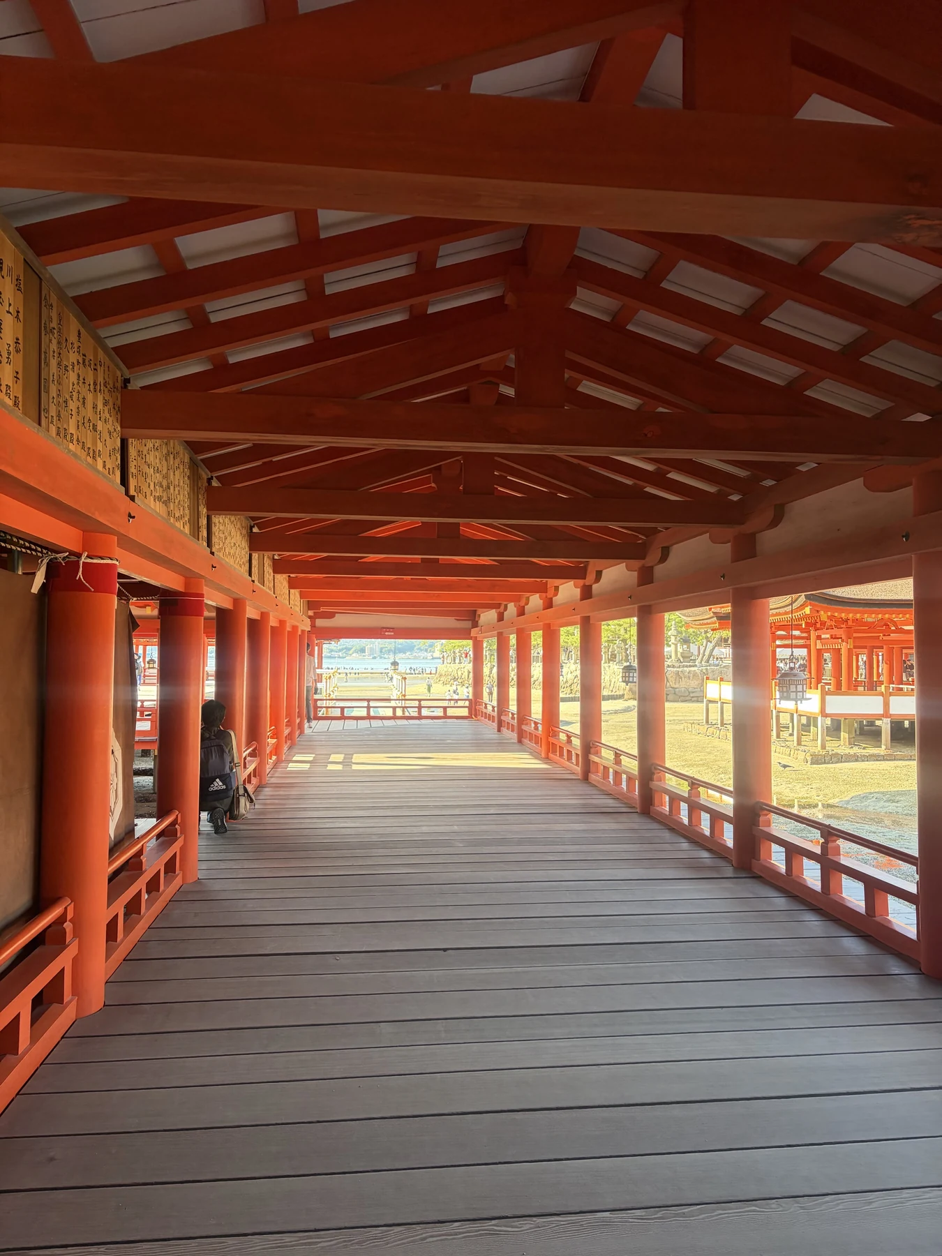 潮が引いた境内と朱色の柱が並ぶ厳島神社の回廊